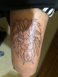 a man with a lion tattoo on his thigh