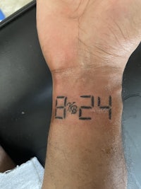 a person's wrist with a clock tattoo on it