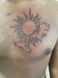 a man with a sun tattoo on his chest